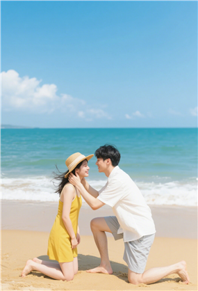 夏日海边沙滩年轻情侣面对面图片